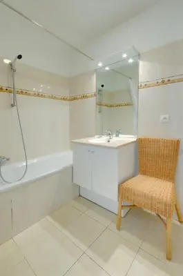 a bathroom with a sink and a mirror and a chair at Villa Kappas - B42 Promenade des Anglais in Nice
