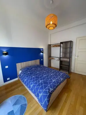 a bedroom with a blue bed and a blue wall at Appartement Niçois in Nice
