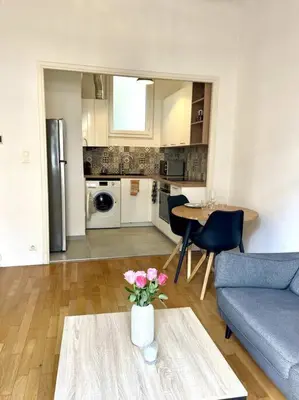 a living room with a couch and a table with flowers at Appartement Niçois in Nice