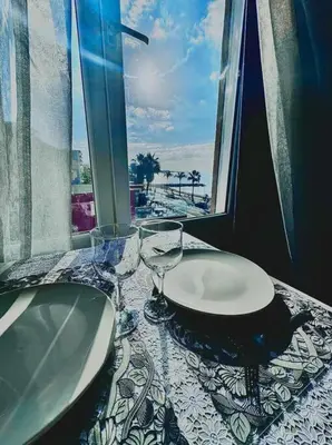 a table with two wine glasses on top of it at Studio en bord de mer, Plage 20m, Clim in Cagnes-sur-Mer