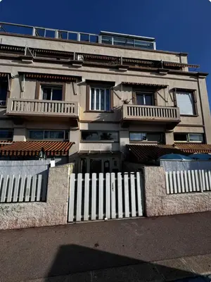 a building with a white fence in front of it at Studio en bord de mer, Plage 20m, Clim in Cagnes-sur-Mer