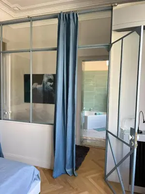 a bedroom with a bed and a large glass window at Appartement exceptionnel belle époque avec grande terrasse plein sud in Nice