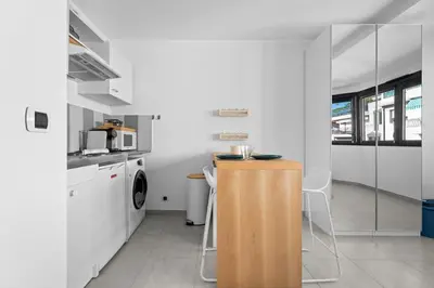 a kitchen with a counter and a washing machine at Studio Amanda - Welkeys in Nice