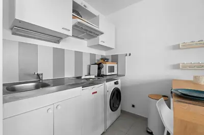 a kitchen with a sink and a washing machine at Studio Amanda - Welkeys in Nice