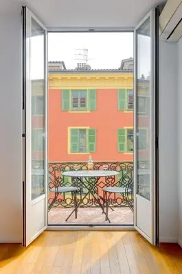 an open door to a patio with a table outside at Rue Fodere location Port area in Nice