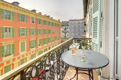 a table on a balcony with a view of buildings at Rue Fodere location Port area in Nice