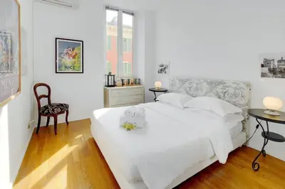 a bedroom with a white bed and a table and chairs at Rue Fodere location Port area in Nice