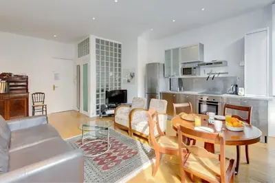 a living room with a table and a kitchen at Rue Fodere location Port area in Nice
