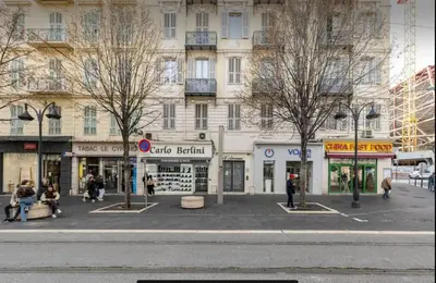 a city street with people sitting in front of a building at Studio confortable à Nice - 19 m² avec vue sur la ville in Nice