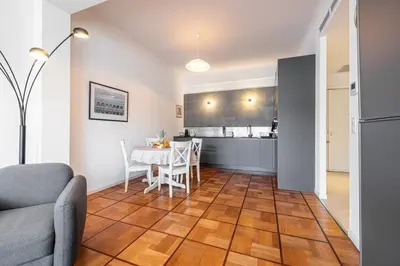 a living room with a table and a kitchen at Royal Riviera in Nice