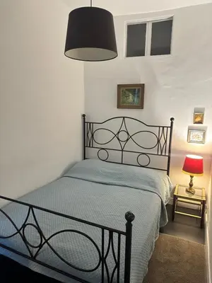 a bedroom with a bed with a blue comforter and a lamp at Vieux Nice in Nice