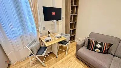 a living room with a table and a couch at Le Petit Saint Barth- Easy Home Booking in Nice