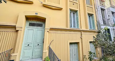 a building with a blue door and a fence at Le Petit Saint Barth- Easy Home Booking in Nice