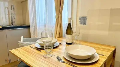 a wooden table with glasses and a bottle of wine at Le Petit Saint Barth- Easy Home Booking in Nice
