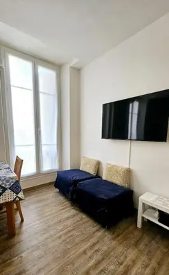 a living room with a couch and a flat screen tv at Studio Nice Centre - Climatisation in Nice
