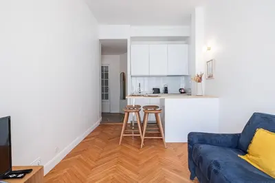 a living room with a blue couch and a kitchen at 10 AMIRAL 201 - Magnifique apt - 2 chambres - Centre-ville in Nice