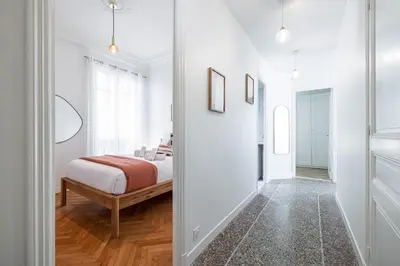 a white bedroom with a bed and a mirror at 10 AMIRAL 201 - Magnifique apt - 2 chambres - Centre-ville in Nice