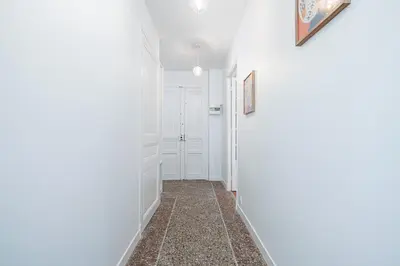 a hallway with white walls and a tile floor at 10 AMIRAL 201 - Magnifique apt - 2 chambres - Centre-ville in Nice