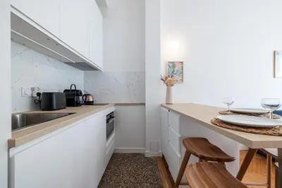 a kitchen with a sink and a counter with stools at 10 AMIRAL 201 - Magnifique apt - 2 chambres - Centre-ville in Nice