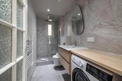 a bathroom with a sink and a washing machine at 10 AMIRAL 201 - Magnifique apt - 2 chambres - Centre-ville in Nice
