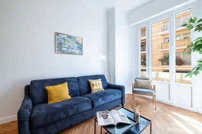 a living room with a blue couch and a table at 10 AMIRAL 201 - Magnifique apt - 2 chambres - Centre-ville in Nice