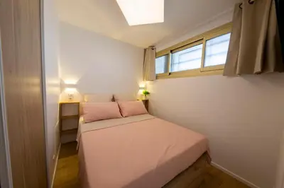 a small bedroom with a bed and a window at 06K1 - Front of the sea-renovated-terraceparking in Saint-Laurent-du-Var