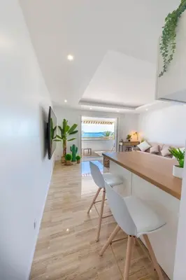 a kitchen and living room with a dining table and chairs at 06K1 - Front of the sea-renovated-terraceparking in Saint-Laurent-du-Var