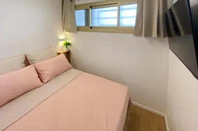a small bedroom with a pink bed and a window at 06K1 - Front of the sea-renovated-terraceparking in Saint-Laurent-du-Var