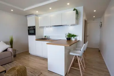 a kitchen with white cabinets and a wooden counter top at 06K1 - Front of the sea-renovated-terraceparking in Saint-Laurent-du-Var