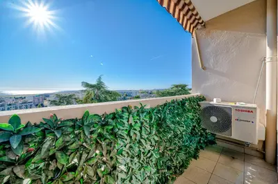 a balcony with a green hedge on a building at Superbe 3p vue mer avec parking in Nice