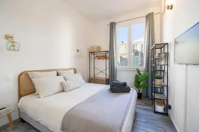 a bedroom with a large white bed and a window at Charming Apt Nice Port Place du Pin with Balcony in Nice