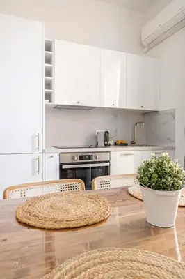 a kitchen with white cabinets and a table with chairs at Charming Apt Nice Port Place du Pin with Balcony in Nice