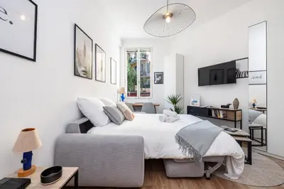 a white bedroom with a bed and a couch at 1 GAUTIER 101 - Joli studio equipe - Quartier du Port in Nice