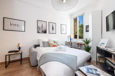a white bedroom with a bed and a couch at 1 GAUTIER 101 - Joli studio equipe - Quartier du Port in Nice