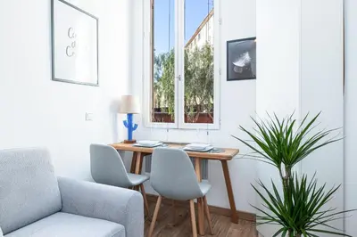 a living room with a table and chairs and a window at 1 GAUTIER 101 - Joli studio equipe - Quartier du Port in Nice