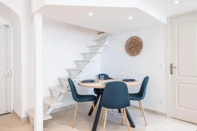 a dining room with a table and blue chairs at 1 LONGCHAMP - Joli appartement - Carre d Or - Climatise in Nice