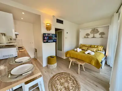 a bedroom with a yellow bed and a kitchen at L'Éclat Safran - Royal Luxembourg in Nice