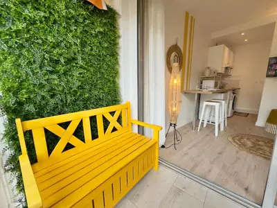 a yellow bench sitting in front of a green wall at L'Éclat Safran - Royal Luxembourg in Nice