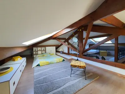 a attic bedroom with a bed and a chair at Villa Moana in Èze