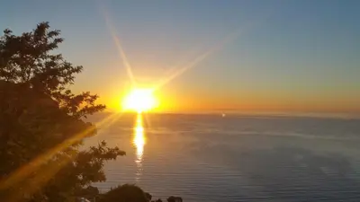 a sunset over the ocean with the sun setting over the water at Villa Moana in Èze