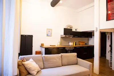 a living room with a couch and a kitchen at Appartement La Mezzanine in Nice