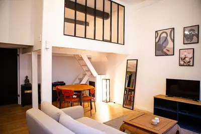 a living room with a white couch and a table at Appartement La Mezzanine in Nice