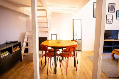 a table and chairs in a room with a loft at Appartement La Mezzanine in Nice