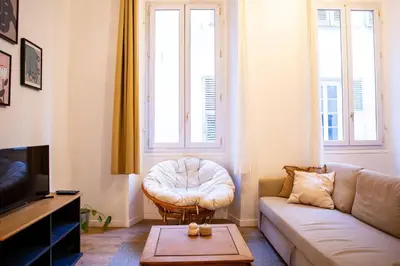 a living room with a couch and a stool at Appartement La Mezzanine in Nice