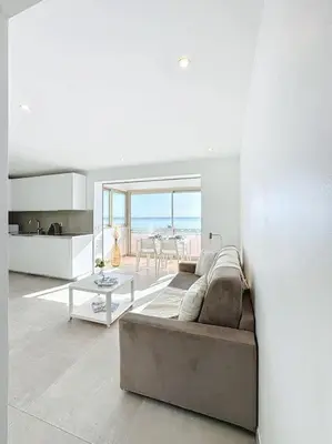 a living room with a couch and a table at Évasion Mer & Vue Imprenable in Saint-Laurent-du-Var