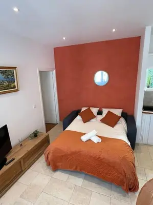 a bedroom with a large bed with a red headboard at Le Village - cosy flat 5 min walk away from sea in Nice