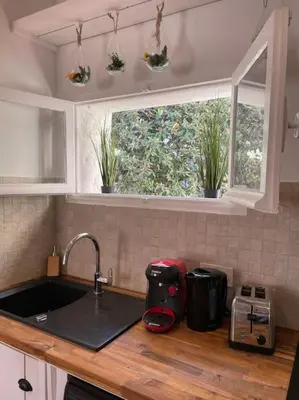 a kitchen counter with a sink and two windows at Le Village - cosy flat 5 min walk away from sea in Nice