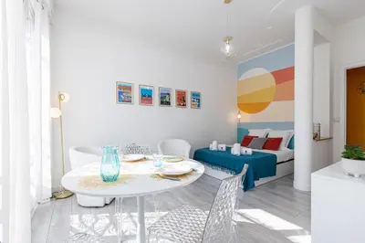 a white living room with a table and chairs at 37 LAMARTINE - Magnifique Studio Art Deco - Centre-ville in Nice
