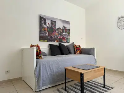a living room with a bed and a table at Studio lumineux in Nice