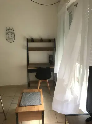 a room with a table and a chair and a desk at Studio lumineux in Nice